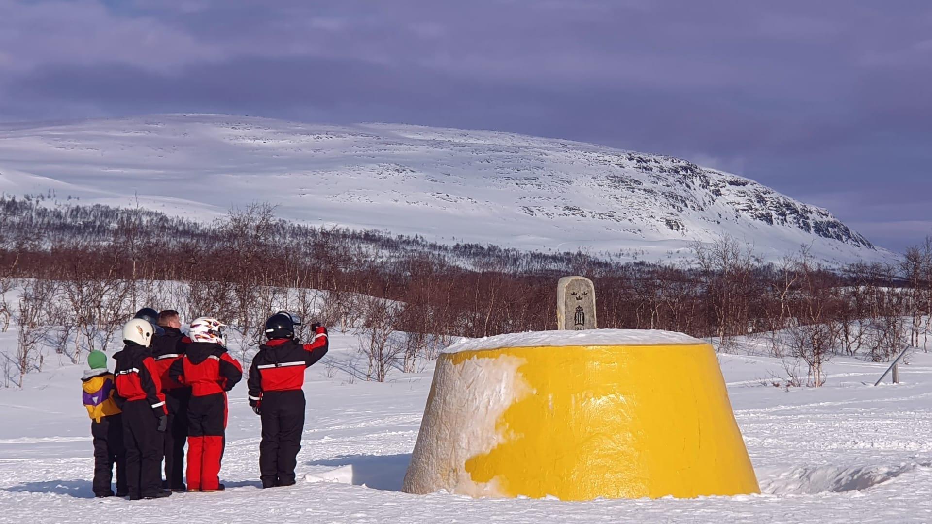 Snowmobile safari guests at the Three-Country Cairn