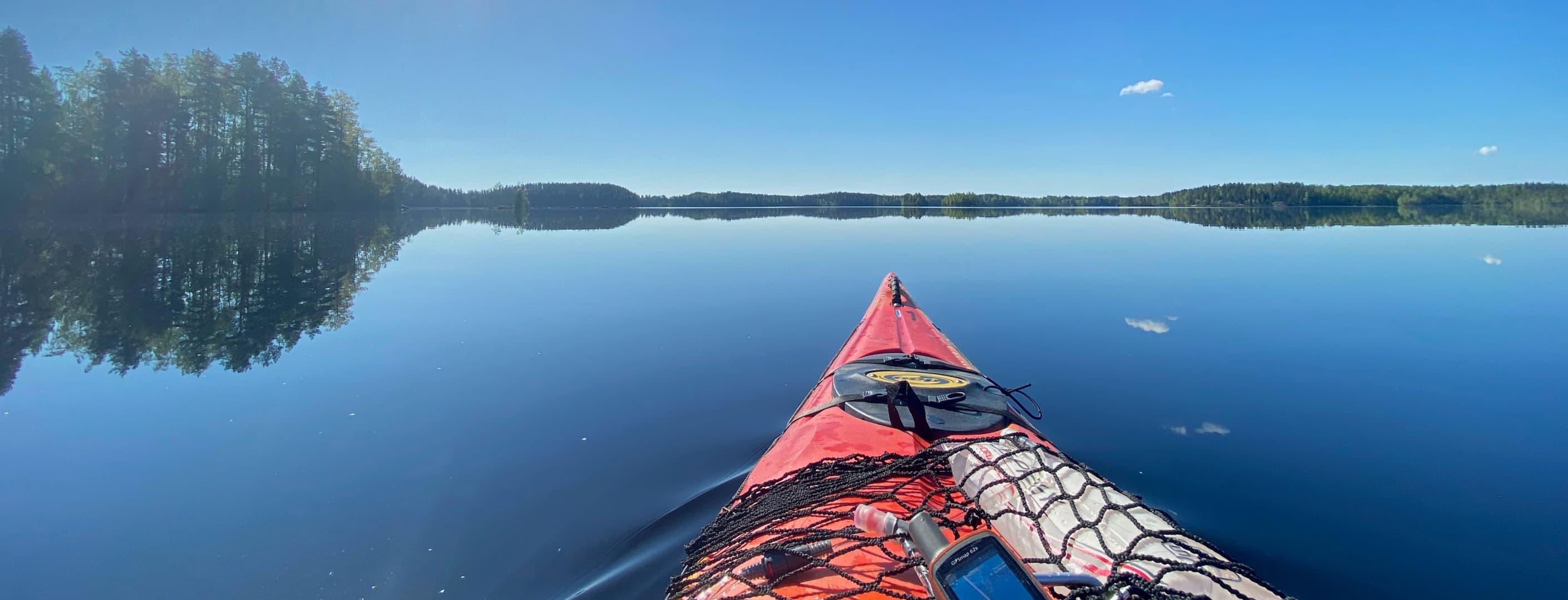 Kuva: Pekka Veijola Kanootti tyynellä järvellä aurinkoisena kesäpäivänä.