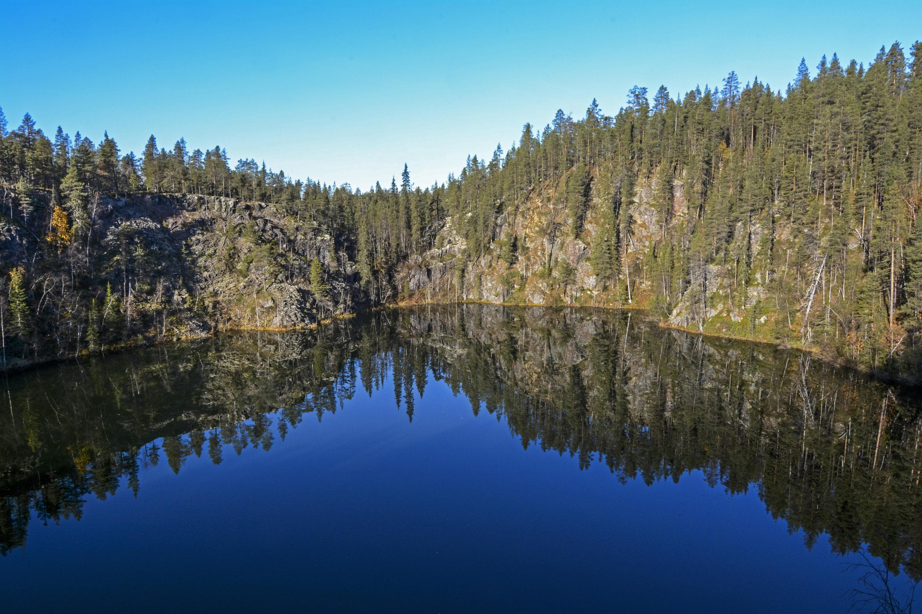 Kuva: Seija Olkkonen Kirkas järvi. Taustalla kohoavat kalliot jossa havumetsää.
