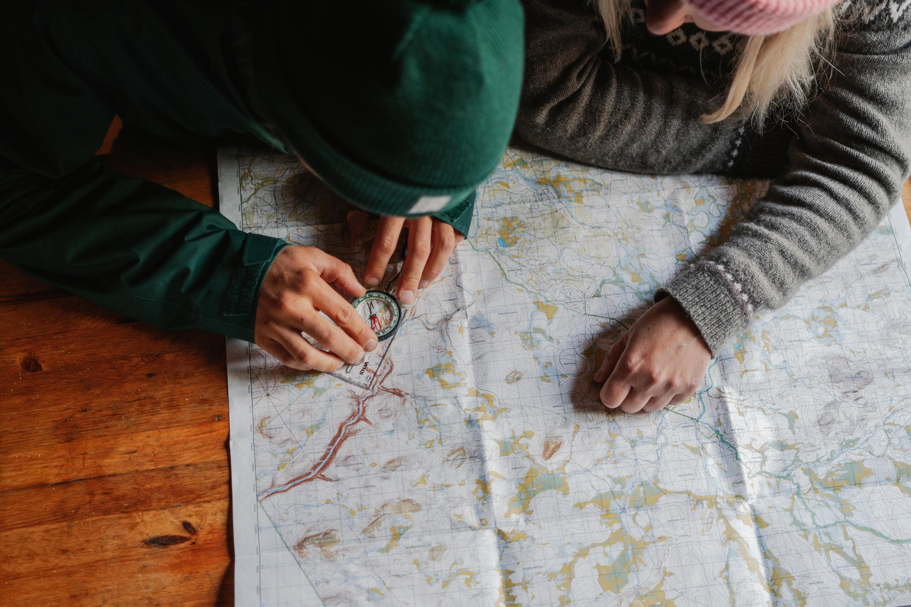Bild: Jaakko Posti Två personer studerar en karta med en kompass.