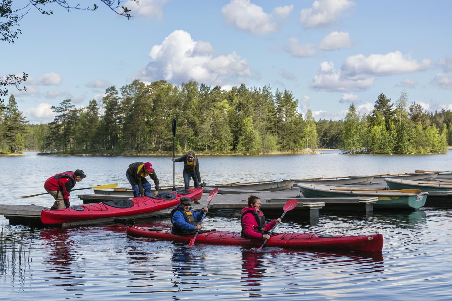 Image: Jari Kostet Two canoes with paddlers preparing to paddle near the dock.