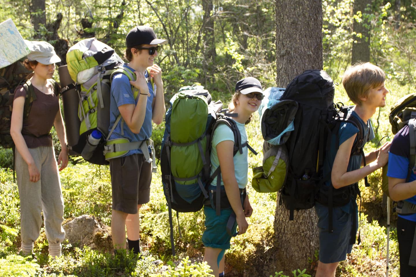 Image: Anemone Aaltonen A group of young people standing on a forest trail with backpacks on their backs.