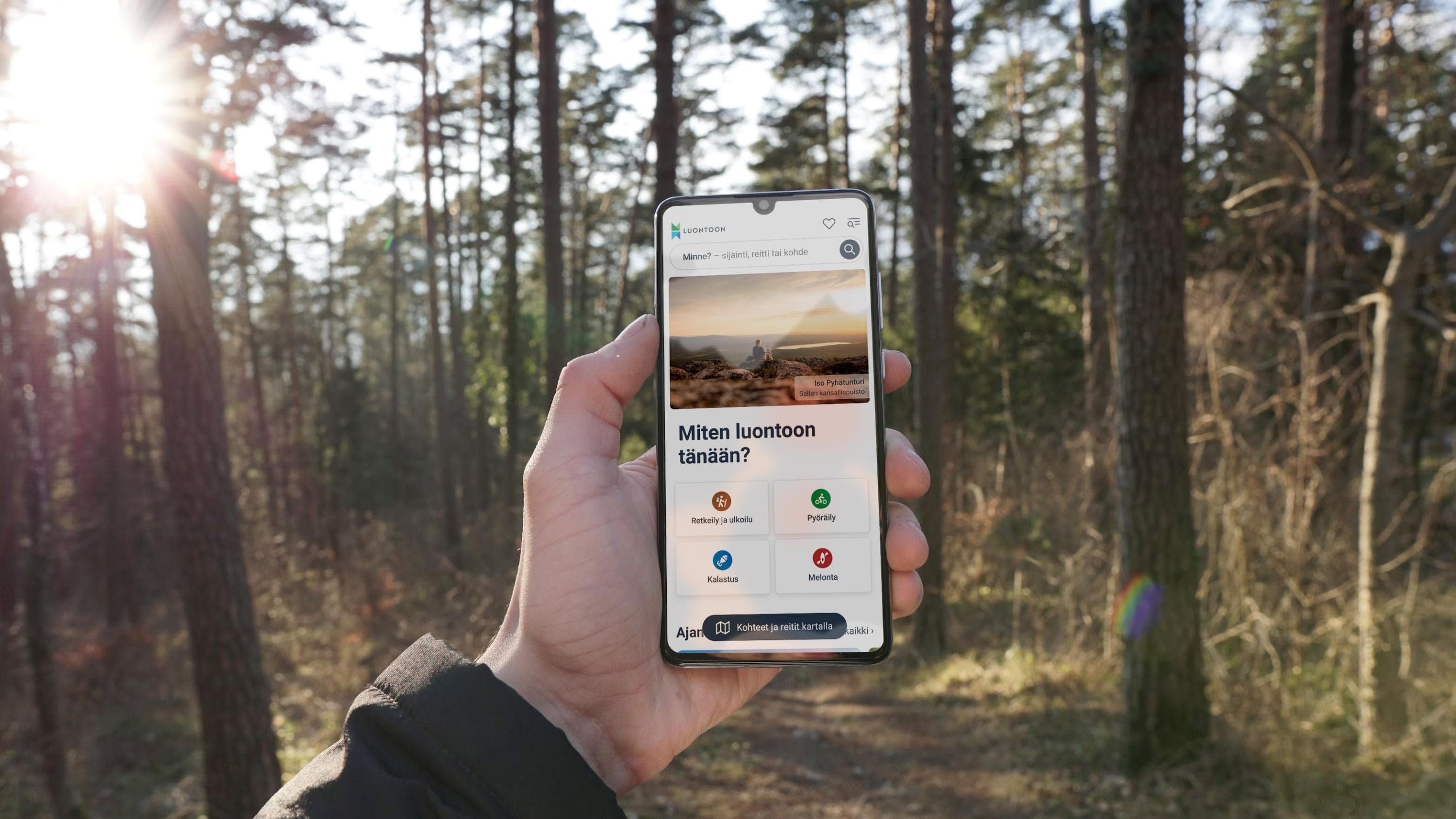 Bild: Metsähallitus. Kädessä olevassa kännykässä näkyy Luontoon-palvelu.