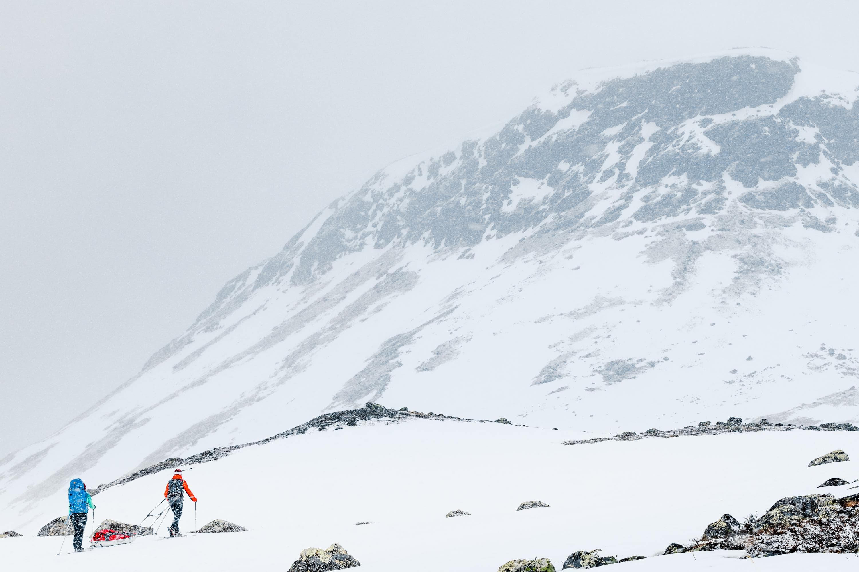 Kuva: Rami Valonen Kaksi hiihtäjää ahkioineen. Taustalla kohoaa Saana-tunturi.