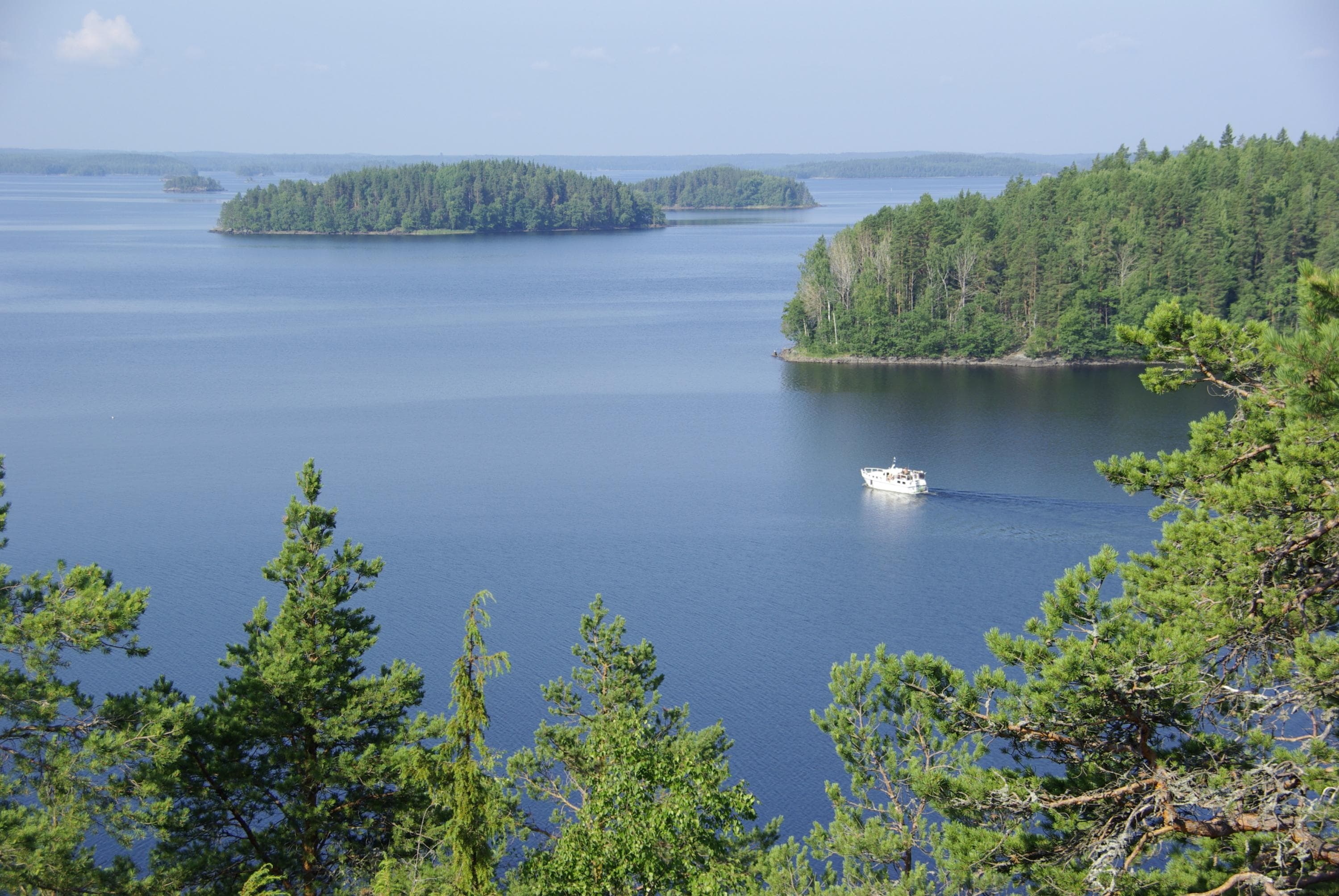 Kuva: Anne Pyykönen Maisema järvelle, jossa on saaria ja vene.