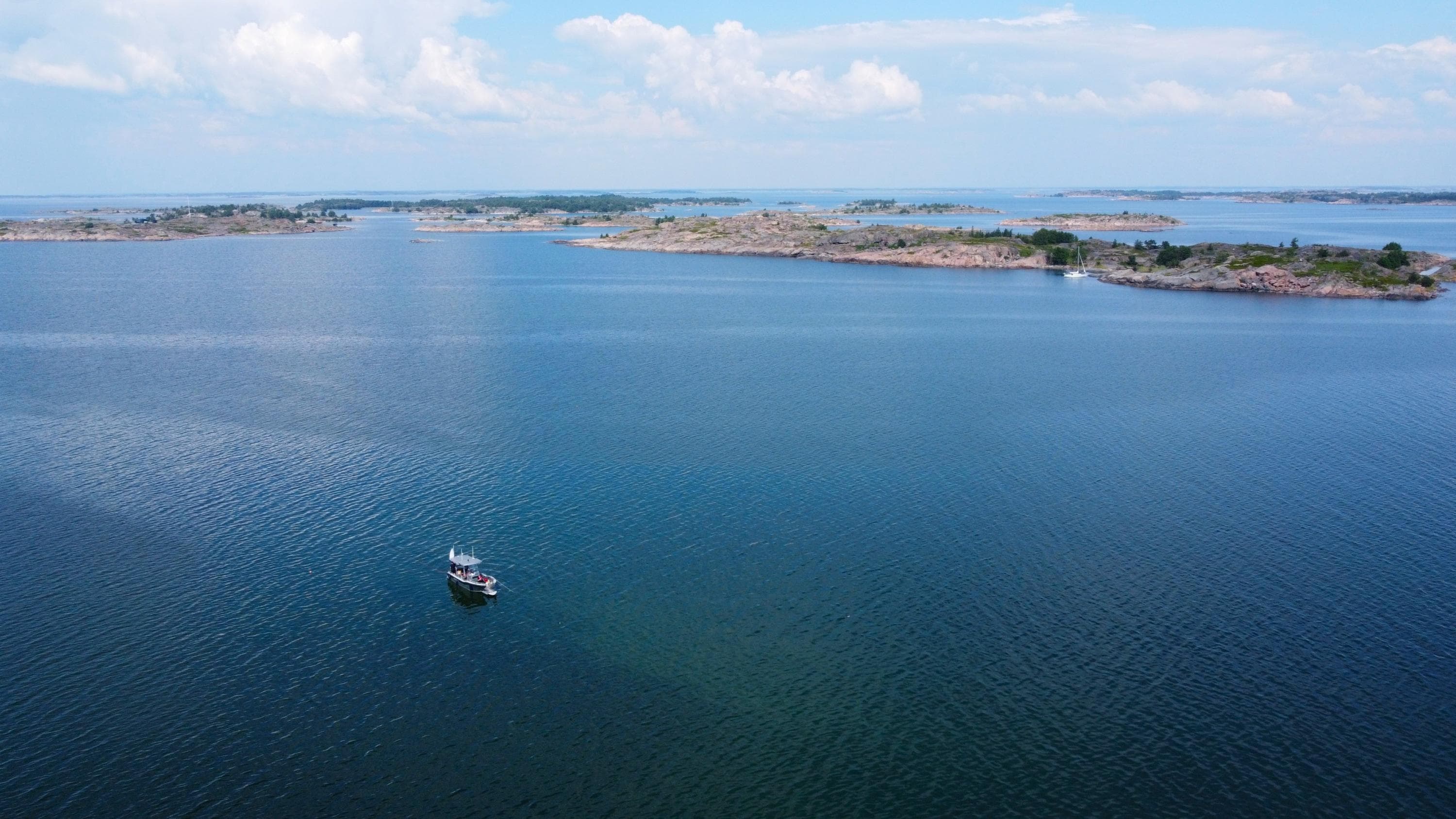 Kuva: Laura Piiroinen Ilmasta otetussa valokuvassa on useita kallioisia saaria ja joitakin veneitä.