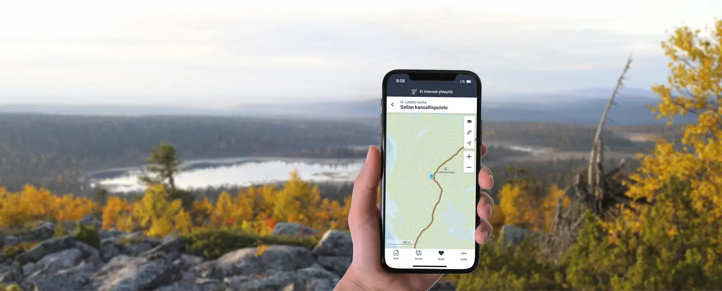 Kuva: Metsähallitus Käsi, jossa on kännykkä ja siinä näkyy Luontoon-sovellus. Taustalla tunturimaisemaa.