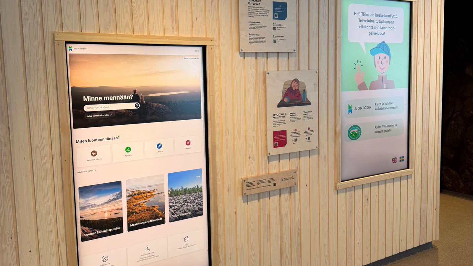 Kuva: Heta Kylmämaa Seinällä on kaksi diginäyttö ja opastustauluja.