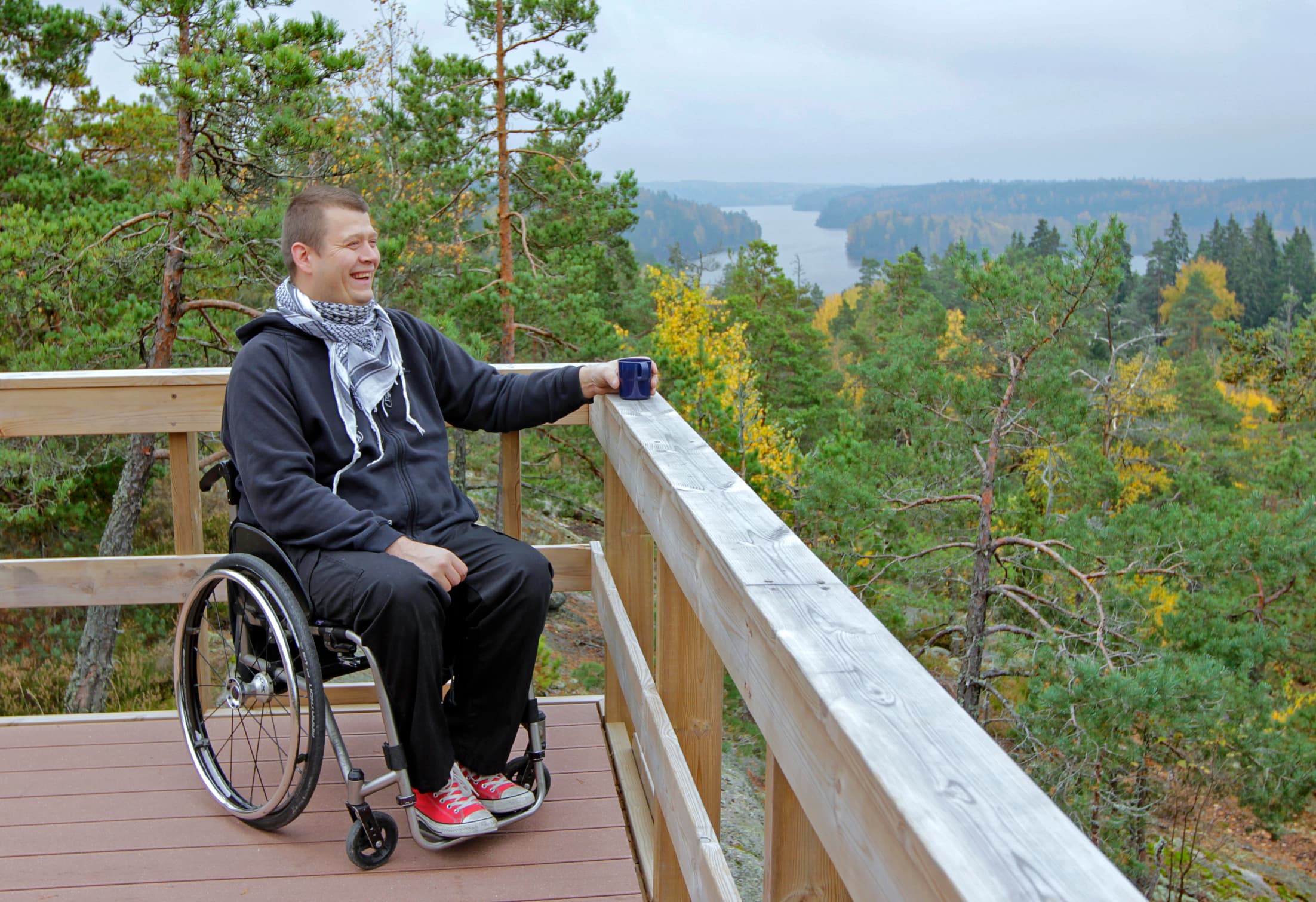 Kuva: Tuomas Uola Retkeilijä pyörätuolilla esteettömän katselulavan kaiteen vieressä syksyllä maisemia katselemassa.