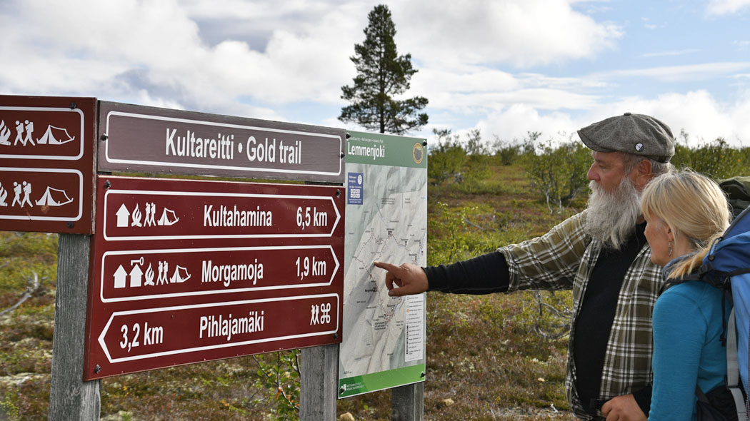 Kaksi ihmistä katsoo maasto-opastetta.